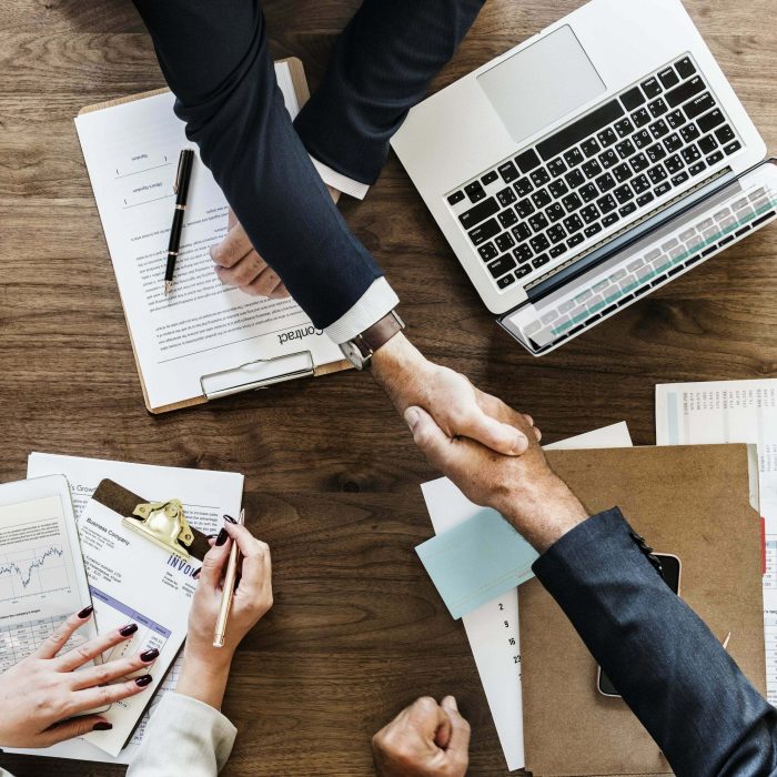 C-Suite Training Simulations Picture of two business people shaking hands to represent the c-suite training and c-suite assessment simulation site.